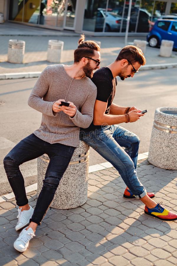Two Friends Sitting in the Street, Talking on the Phone Stock Photo - Image  of black, attractive: 105467084